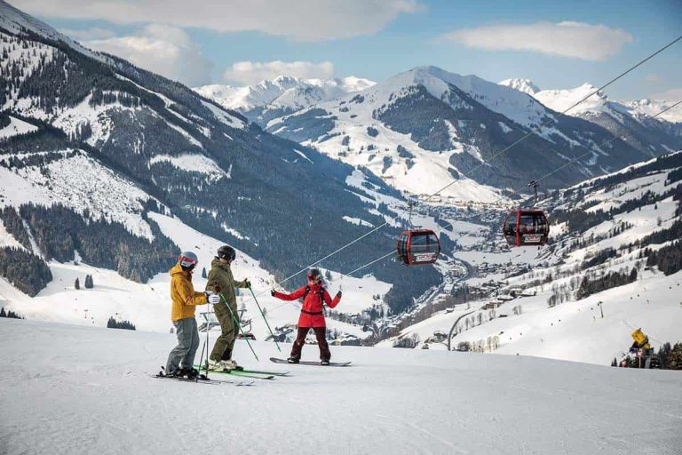 Skifahrer genießen die Alpenlandschaft in Saalbach Hinterglemm bei strahlendem Sonnenschein.