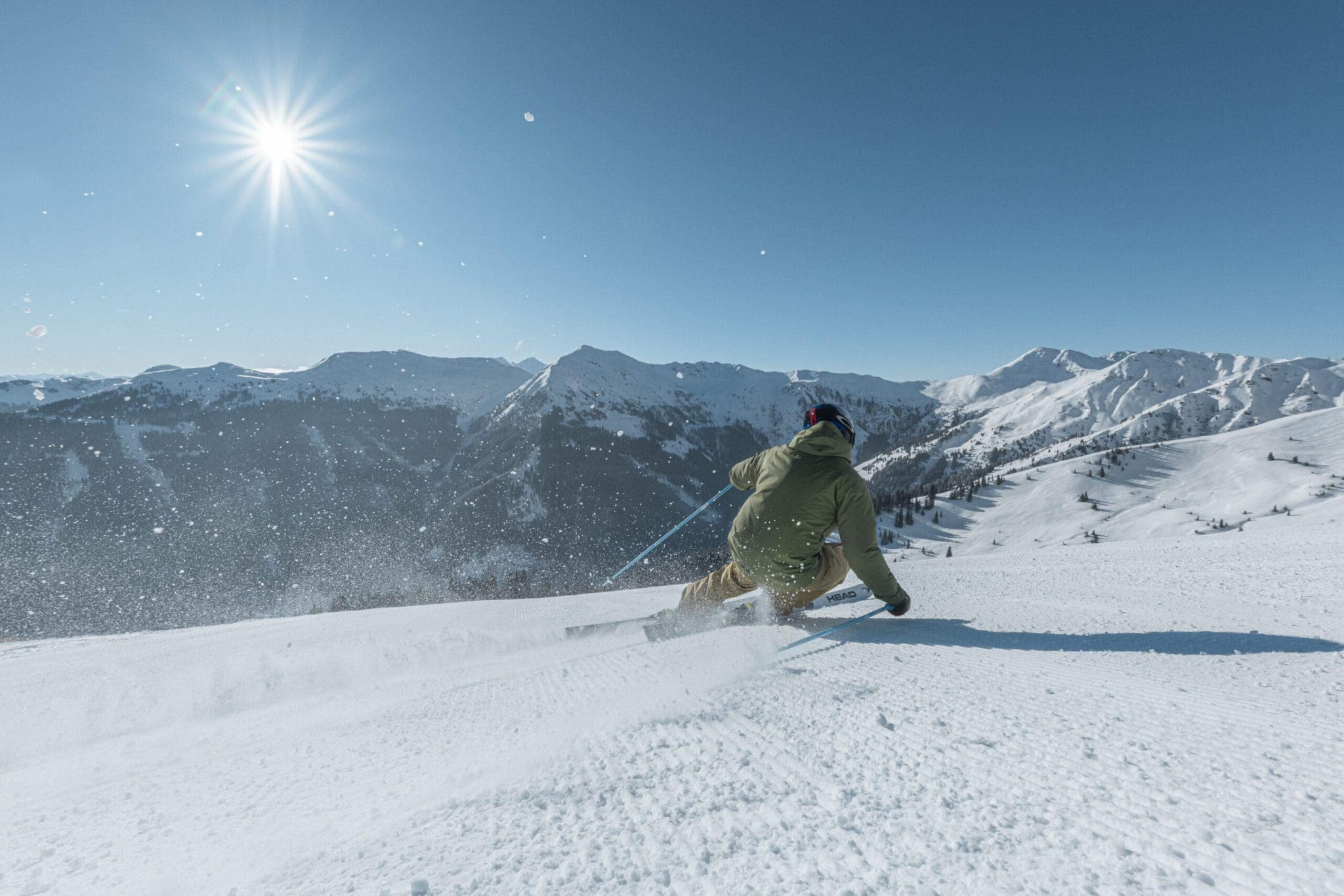 Skifahrer auf unberührter Piste vor alpiner Winterlandschaft in Saalbach Hinterglemm.