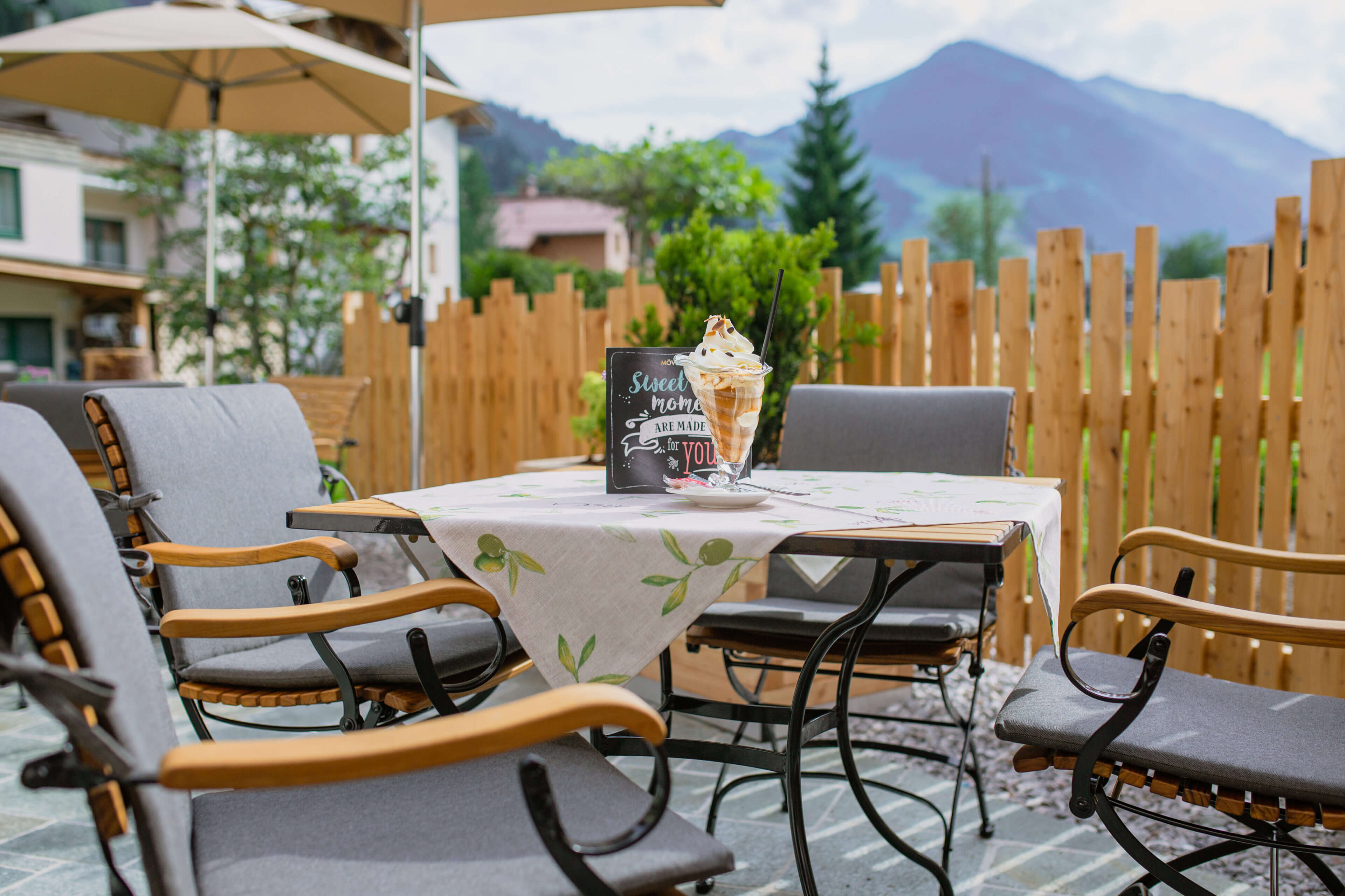 Terrassenbereich mit Eisbecher und Sitzmöbeln im Hotel Barbarahof Saalbach im Sommerurlaub